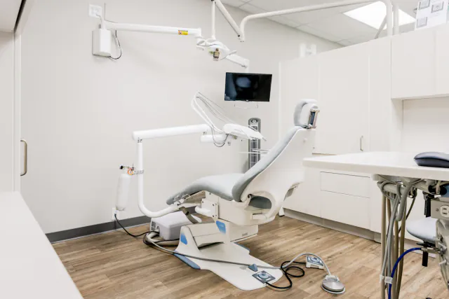 Gabinete de clínica dental luminoso con sillón y equipo de trabajo